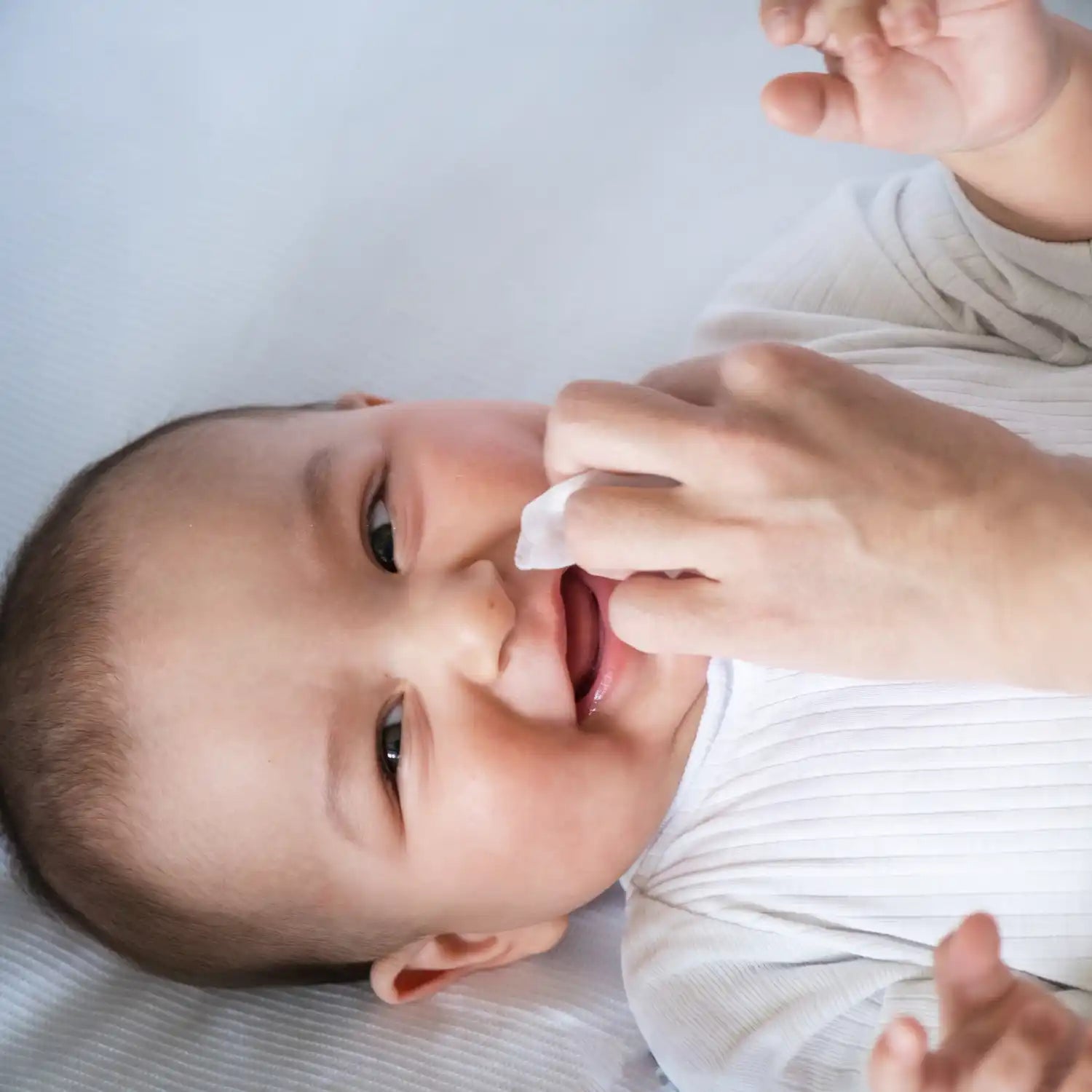 Een baby die wordt schoongemaakt met een doekje.