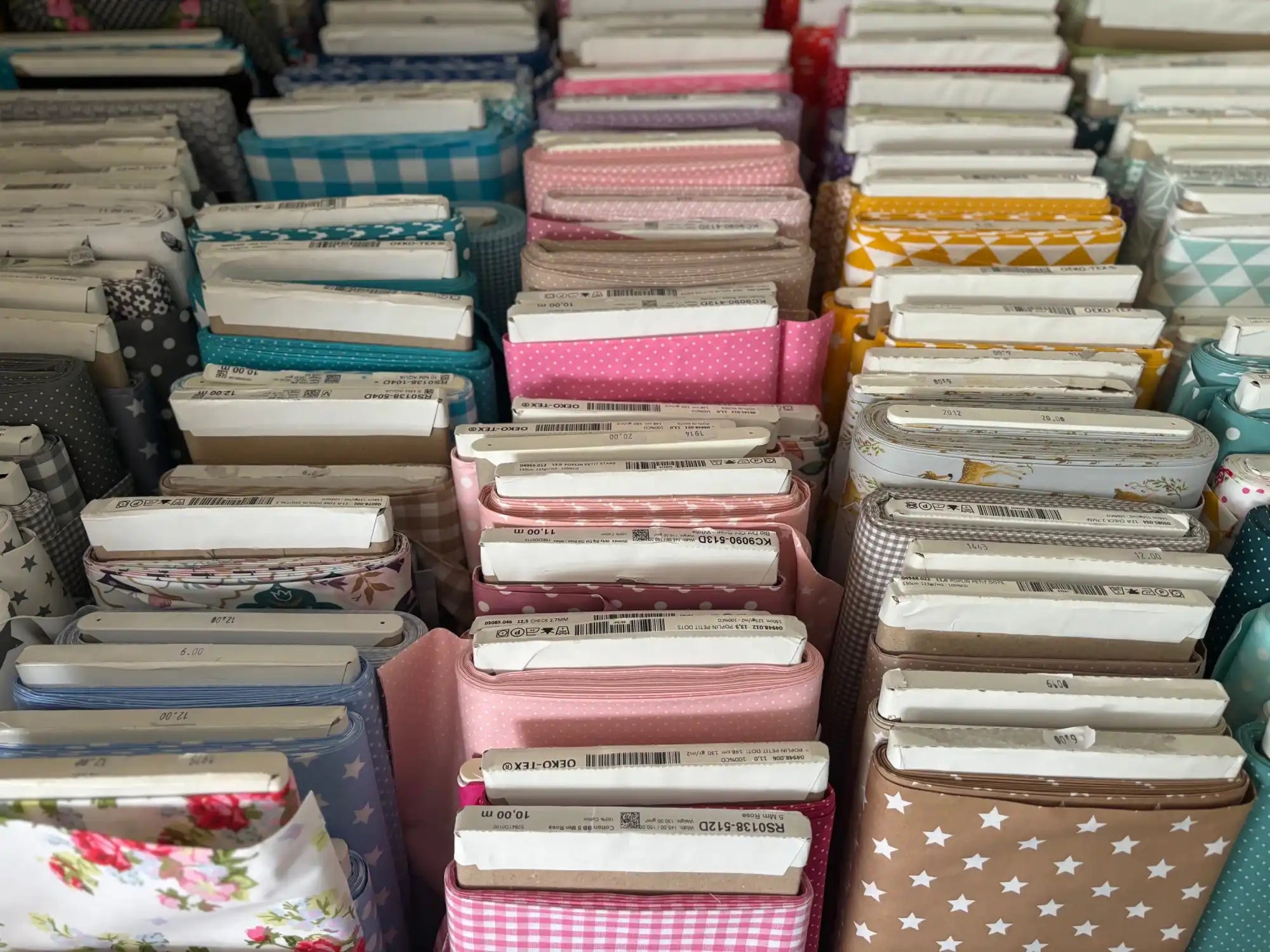 Nette gestapelde bunchen met verschillende patroon en gekleurde stoffen.