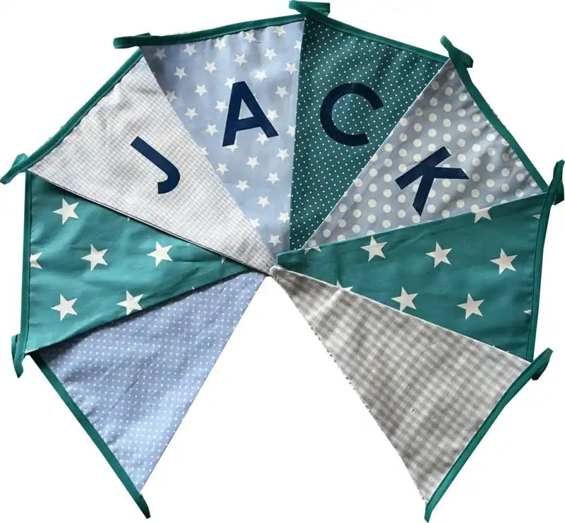 Een kleurrijk stoffen slinger met de tekst 'JACK' en verschillende patronen.