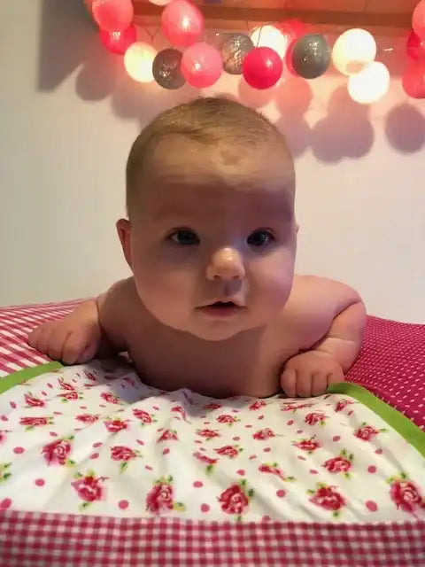 Een zuigeling op een met een patroon bedekte deken.